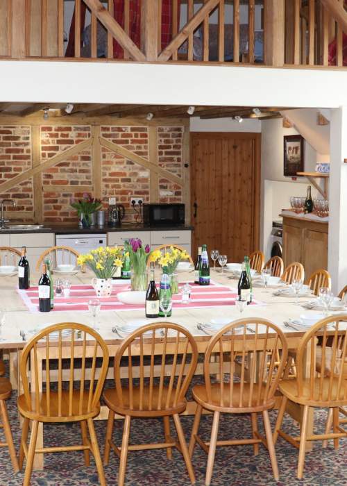 Dining and kitchen area of farm barn accommodation in the New Forest