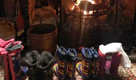 Line of wellie boots in front of fire at Waterloo Arms pub in Lyndhurst in the New Forest - Pub walks insp